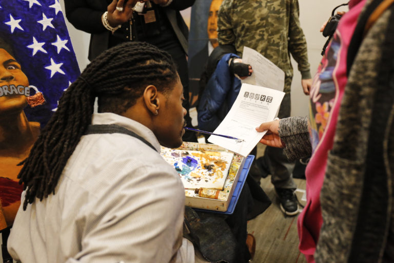 Students interact with mouth painter Antonio Davis during his talk and demonstration of his art.