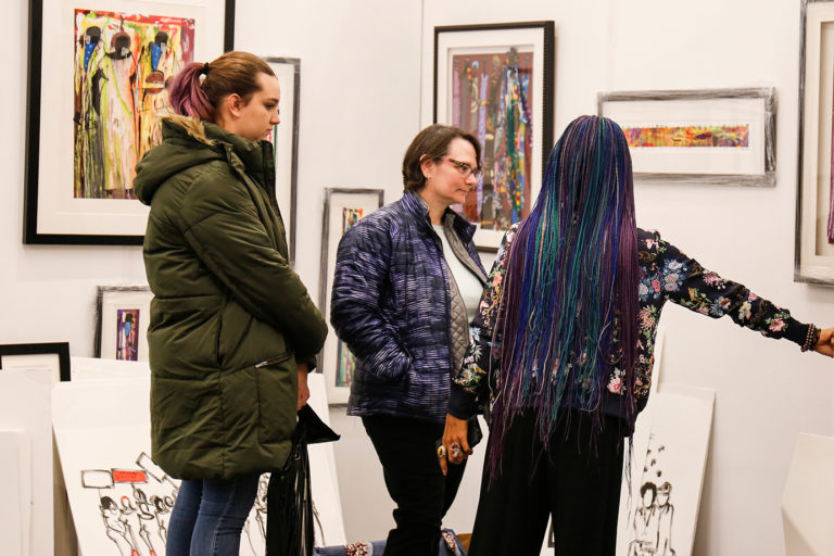 Guests engaging with art and artist
